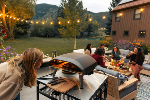 Koda 16 Inch Propane Gas Pizza Oven With 28 MBAR Regulator And Hose Outdoor Portable Oven beside a group on a patio