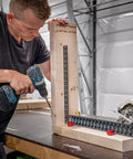 Man using stair gauges for framing square with non slip grip on wooden board in workshop, heavy duty framing jig for speed squares.