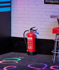 Rad Miniature Resin Fire Extinguisher 1/4 Scale Replica next to a barstool in an arcade room diorama setup.