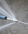 7 Pack 4000 PSI Sewer Jetter Nozzle Kit in use, showing rotating button nose spraying water for drain cleaning.