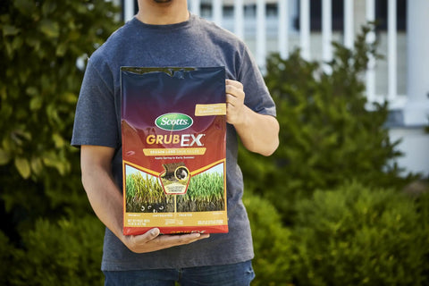 Person holding GrubEx1 Season Long Grub Killer For Lawns Kills Grubs When Young And Prevents Turf Damage For Up To 4 Months