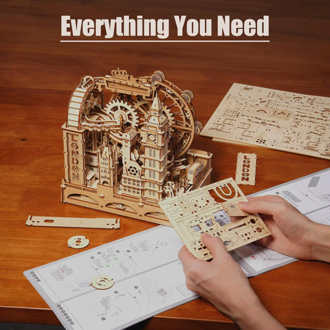 London Themed 3D Wooden Marble Run Puzzle for Adults, 431 Piece DIY Construction Kit With Movable Double Decker Bus And Big Ben, Brain Teaser Gift for Teens And Adults. Wooden puzzle parts and instructions laid out on table