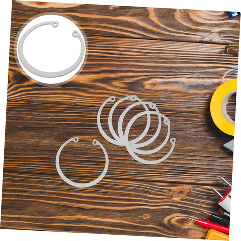 Stainless Steel Snap Ring Kit Five Piece C Clips Circlips Retaining Rings on wooden surface, rust resistant 304 stainless steel