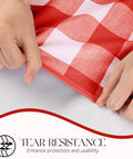 Hands displaying tear resistance of Rectangle Vinyl Tablecloth Waterproof Buffalo Gingham Red For Outdoor Picnics And Camping Heavy Duty Wipeable Table Cover 54 X 78 Inches For Parties Barbecues And Meals, with close-up of red plaid pattern.