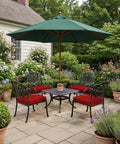 Patio scene with garden chairs and a large green umbrella under lush greenery