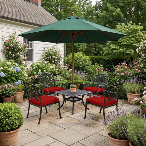 Patio scene with garden chairs and a large green umbrella under lush greenery