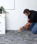 Person installing Heavy Duty Vinyl Cove Wall Base Molding Trim In Aircraft Carrier Finish with flexible strength in an office.