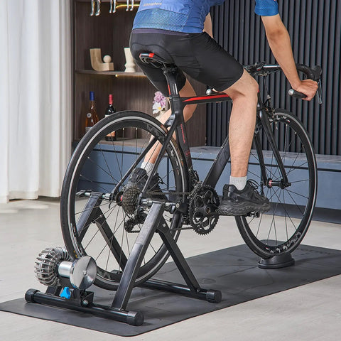 Cyclist using Foldable Fluid Bicycle Trainer Stand For Dope Indoor Rides With Progressive Resistance And Quiet Low Noise Operation