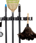 Beefy Heavy Duty Broom Wall Mount Organizer With Four Slots And Hooks shown holding broom, mop, and feather duster