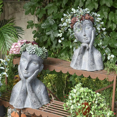 Cool Modern Impressionist Face Planter Pot For Indoor Outdoor Use With Drainage Hole Cactus And Succulent Planter Gray Aged Concrete Finish Polystone Farmhouse Decor Hand Painted Sage Green Floral Crown 11x8.5x16.5 Inches displayed on a garden bench