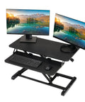 32 Inch Adjustable Standing Desk Converter For Home Office Sit To Stand Desk Setup With Keyboard Tray And Dual Monitor Riser Black Height From 4.3 To 19.7 Inches showing dual monitors and keyboard tray.