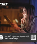 Woman smiling while using a tablet in a cozy setting with dim lighting.