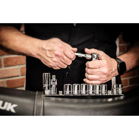 Hands using ratchet from Go-To Motorcycle Tool Kit With Roll Pouch For Roadside And Travel Repairs, includes sockets for quick fixes.