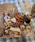 Portable Wine Picnic Table in Acacia Wood With Larger Foldable Tray Charcuterie Board Surface holding wine and snacks