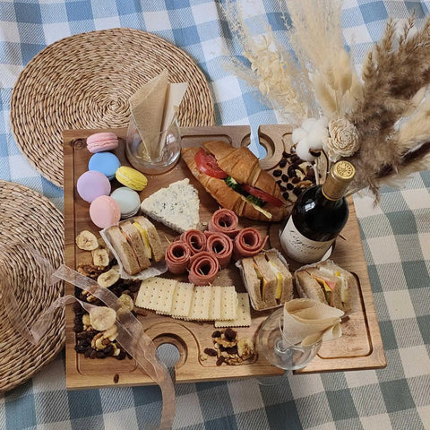 Portable Wine Picnic Table in Acacia Wood With Larger Foldable Tray Charcuterie Board Surface holding wine and snacks