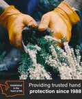Person wearing Orange 8 Mil Nitrile Disposable Gloves Heavy Duty For Mechanic And Auto Shop Work Latex Free Powder Free Puncture And Chemical Resistant XXL 2 Boxes Of 100, handling plants outdoors.