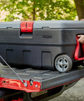 ActionPacker 35 Gallon Lockable Storage Bin with Wheels placed on truck bed for outdoor use