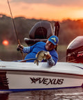 Fisherman holding a fish on a boat at sunset, using Wally Marshall Signature Series Underspin Fishing Reel With All Metal Gears 2 Plus 1 Bearings 4 Point 3 To 1 Gear Ratio Reversible Handle Smooth Casting And Retrieval For Easy No Fuss Fishing.