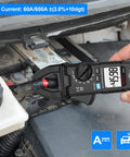 True RMS Clamp Meter Multimeter measuring DC current on car battery, showing 459.8 on LCD display, auto-ranging feature visible