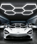 Hexagon LED Garage Light 168W 5 Grid Kit With 18480LM Ultra Bright 6500K Daylight Output installed above luxury cars in a garage.