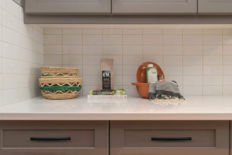 Modern kitchen with matte black Six Inch Curved Cabinet Pulls on drawers and decorative items on countertop.