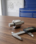 Heavy Duty Steel Hydraulic Pallet Jack Handle Roller With Gleaming Polish on a wooden table beside measurement calipers.