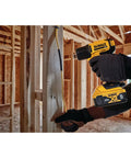 Person using Cordless Heat Gun With LED Light And Lock On Convenience, No Cord, All Power, Hits Up To 990 Fahrenheit, Roughly 42 Minutes Runtime Per Charge, Includes Flat And Hook Nozzle Attachments, Tool Only DCE530B in a construction site