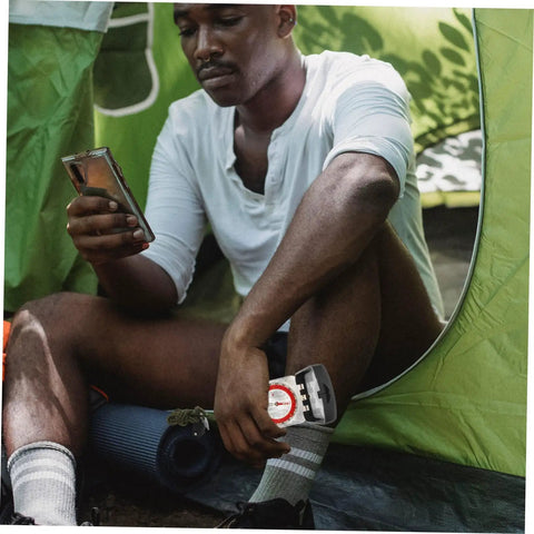 Man sitting in tent with Orienteering Compass Ruler Navigation Tool For Hiking And Camping With High Precision Dial And Luminous Coating