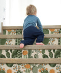 Child climbing stairs with Desert Cactus Wallpaper Peel And Stick Floral Cacti And Succulents Boho Wall Mural on risers.
