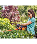 Woman using 40V MAX Cordless Hedge Trimmer With 24 Inch Dual Action Blade, No Cords Needed, Long Battery Life, outdoors