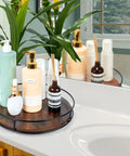 12 Inch Lazy Susan Slick Counter Turntable Kitchen Spice Rack Rustic Brown Wood Swivel Tray holding skincare products on vanity.