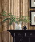 Brown Bamboo Peel And Stick Wallpaper Roll For Easy Removable Wall Decor, self-adhesive repositionable covering behind a vase on a table.