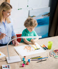 Child painting under Uno LED Art And Craft Table Lamp With Independent Switch Flexible Arm And Single Adjustable Head For Precise Daylight Lighting White Finish For Your Desk Studio Or Craft Setup.