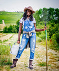 Person in overalls holding Heavy Duty Outdoor Farming Fork For Gardening And Lawn Cleanup With Iron Pitchfork And Grass Fork.