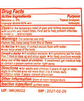 Close-up of first aid kit label showing drug facts, active ingredients, uses, warnings, and directions in red text.