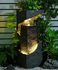 35.4 Inch Tall Indoor Outdoor Dope Waterfall Fountain With LED Lights surrounded by lush greenery for patio decor