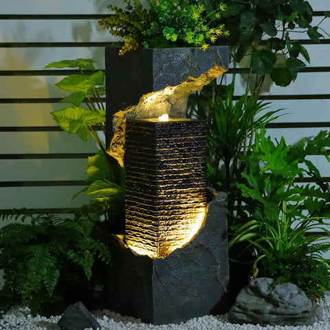 35.4 Inch Tall Indoor Outdoor Dope Waterfall Fountain With LED Lights surrounded by lush greenery for patio decor