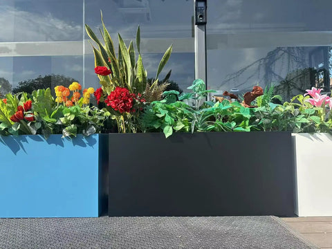 40 Inch Long Metal Rectangular Planter Box For Outdoor Patio Porch Black Modern Design Built To Last No Tool Needed Quick Snap In Planter filled with plants and flowers outdoors