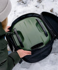 Person packing Tread pizza oven into Venture Bag For Tread Pizza Oven And Roof Rack, Rugged Nylon Carry Case with reinforced top.