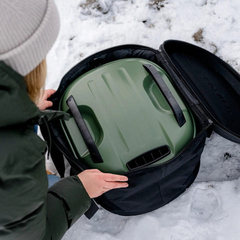 Person packing Tread pizza oven into Venture Bag For Tread Pizza Oven And Roof Rack, Rugged Nylon Carry Case with reinforced top.
