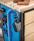 Dust Right Click-Connect Bench Brush And Dock Kit attached to FlexiPort hose on woodworking bench with pegboard.