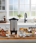 40 Cup Coffee Urn For Office And Events With Fast Brew Aluminum Construction on a kitchen counter with pastries and fruit bowls.