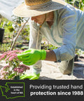 Gardener wearing green gloves tending to pink flowers outdoors, showcasing hand protection. Established in WA, trusted since 1988.