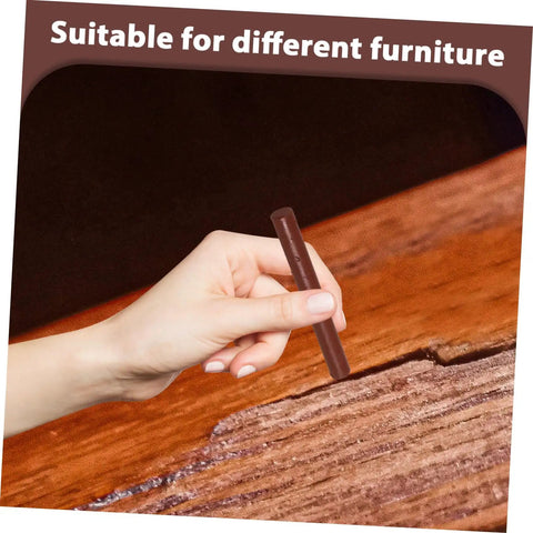 Hand using Dark Brown Wood Repair Kit Wax Filler Sticks For Floors Cabinets And Surfaces Easy To Use No Mess Scratch Repair Crayons