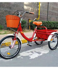 Red adult tricycle with back cabin cargo, dual brakes, front fork shock absorber, PU leather seat, pneumatic wheels on road.