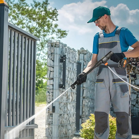 Man using Cordless Pressure Washer 652 PSI 1 GPM Brushless Motor Rechargeable 4Ah Battery Powered Handheld Washer Gun on gate