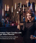 Woman using wand remote to control spooky LED floating candles with flickering warm light in vintage room.