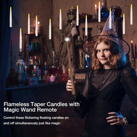 Woman using wand remote to control spooky LED floating candles with flickering warm light in vintage room.