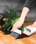 Using Compact Dustpan And Brush Set With Snap In Design and Bristle Cover to clean soil from countertop