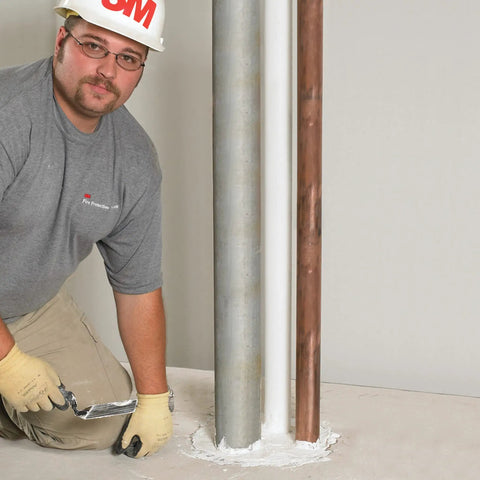 Technician applying Fire Barrier Mortar Ready To Mix Pumpable For Large Annular Spaces And Floors Gray Lightweight Polypropylene